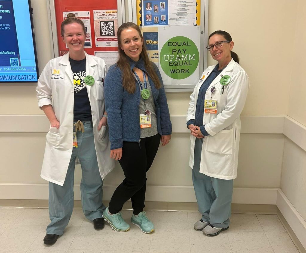 Three healthcare providers smiling toward the camera.
